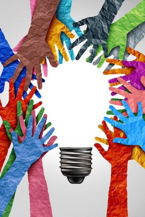 Hands reaching together to form the shape of a lightbulb — AI