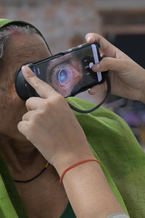 A person uses Visilant's smartphone attachment to take close-up images of another person's eye — AI