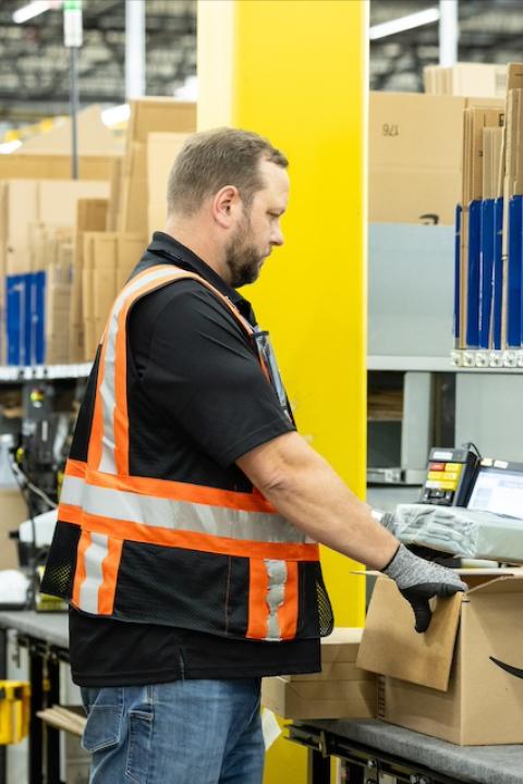 An Amazon employee packaging an order — artificial intelligence.