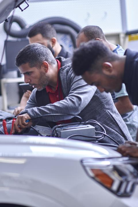 Students working on vehicles as a part of the Audi Education Partnership.