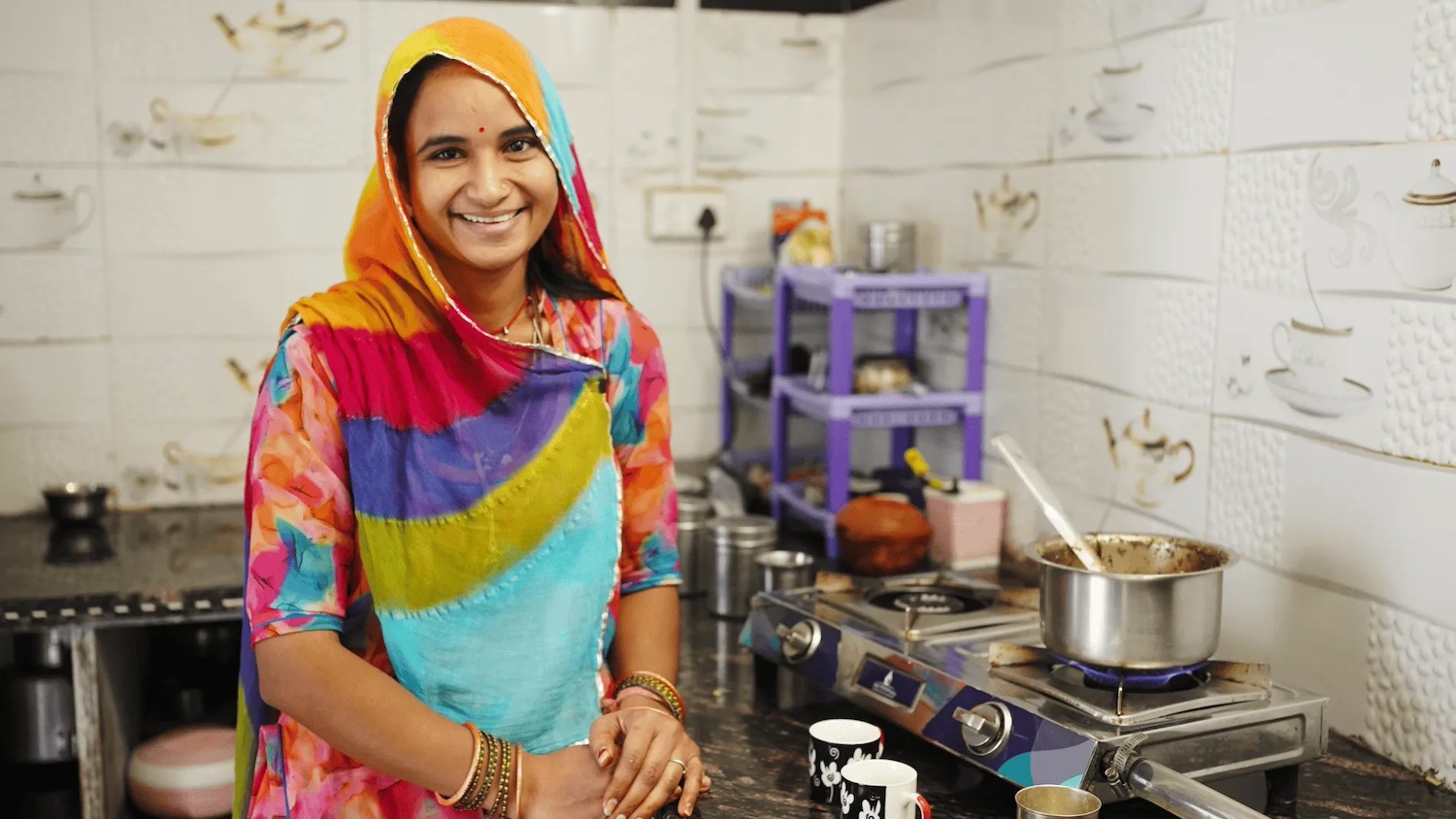 Pooja Singh cooks on a two-burner cookstove in their kitchen that's connected to a Sistema.bio biodigester.
