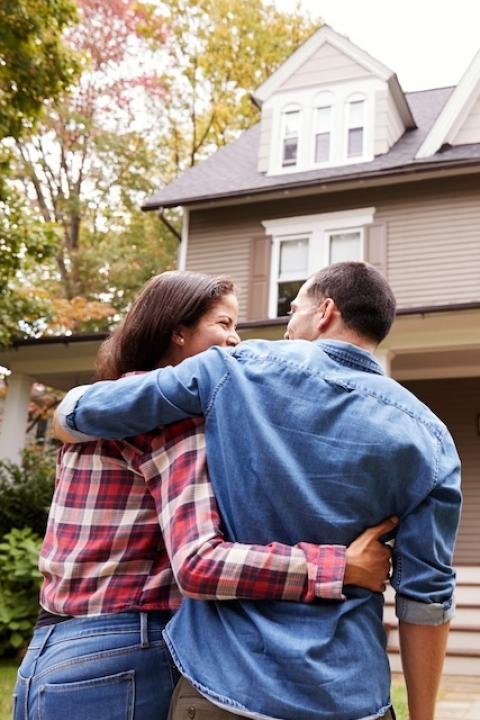 A couple standing together in front of a home — CDFIs