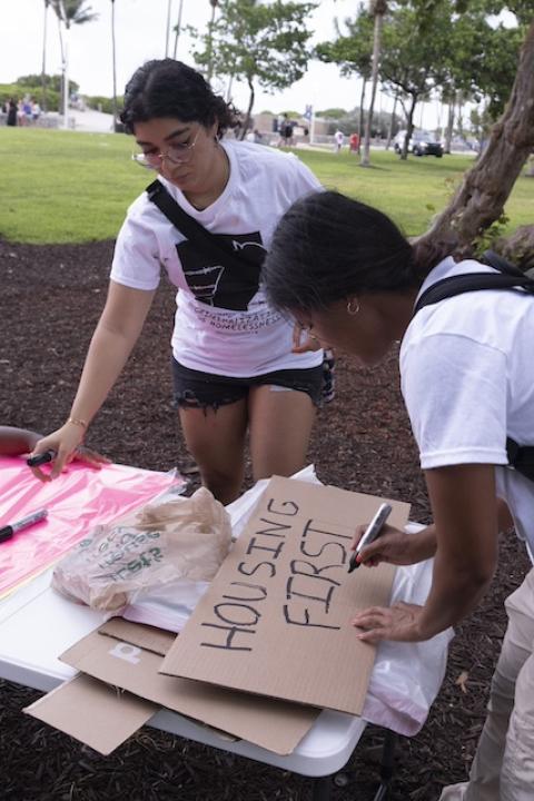 The SMASH team creates a sign that reads "housing first" — climate gentrification