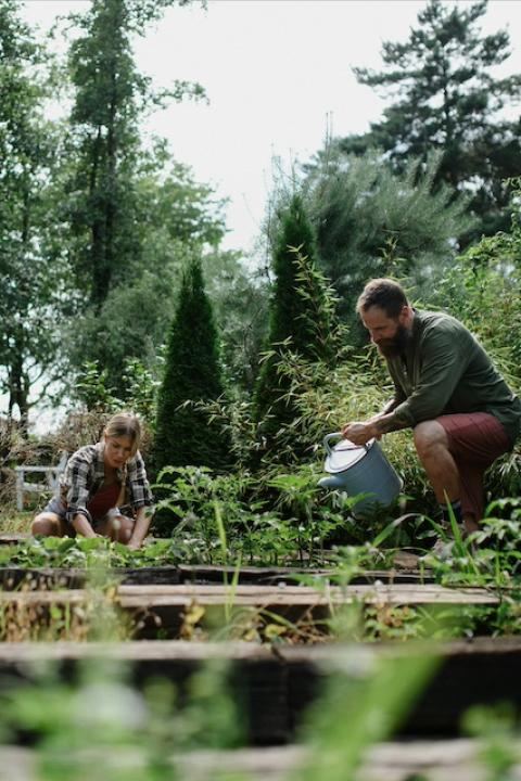 Three people caring for crops at a community garden — community composting