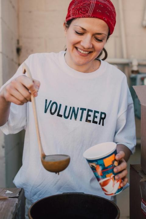 A volunteer serving soup — corporate giving