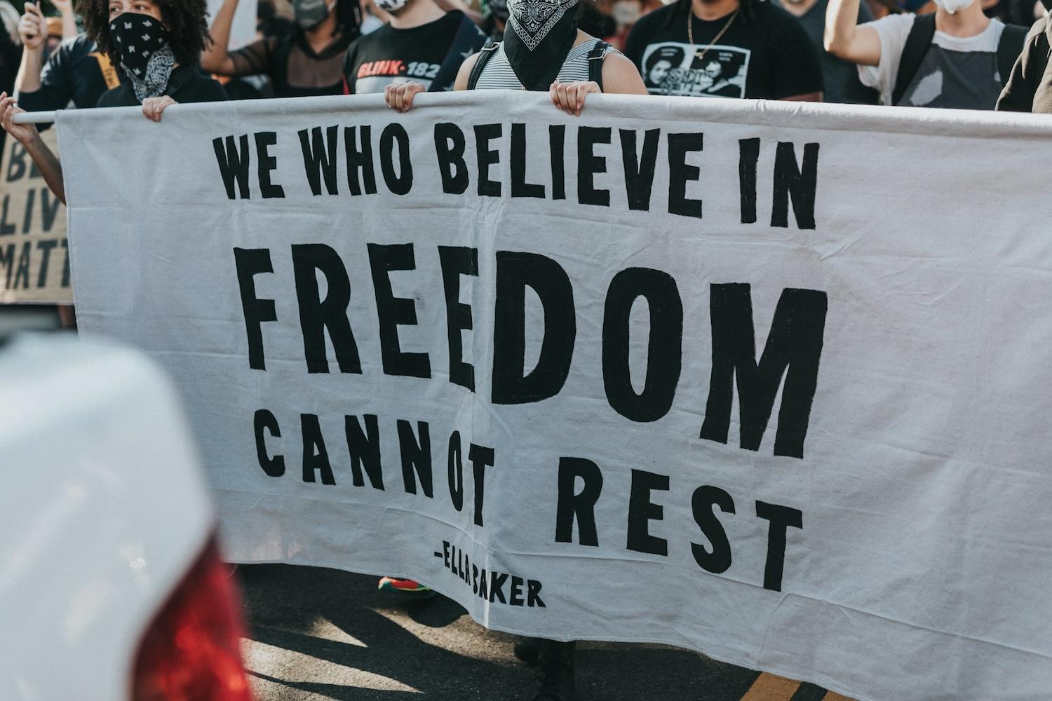 demonstrators carry a sign in support of racial equity and improving black communities at a demonstration after the death of george floyd