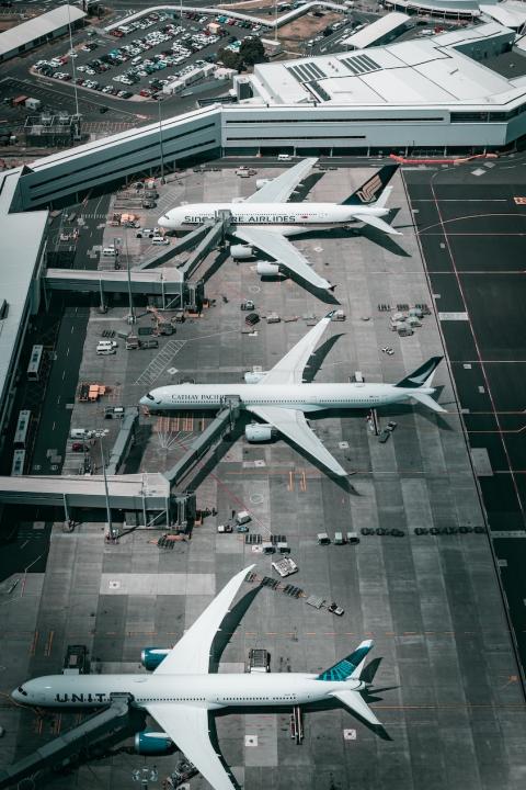 Planes parked on the tarmac at an airport.
