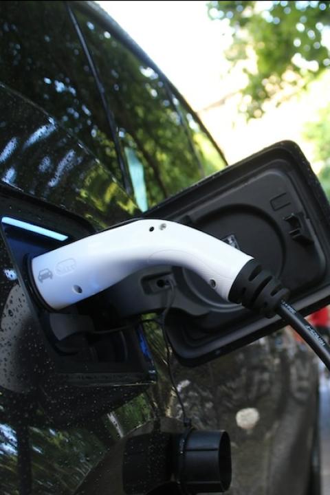 electric vehicle with charger plugged in - electric vehicles