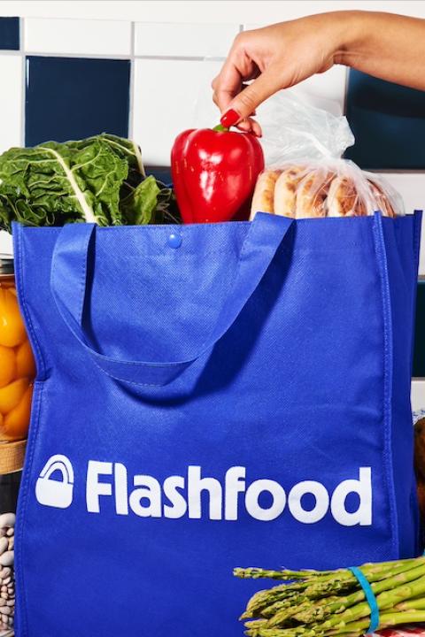 A person grabbing produce out of a bag from the food waste app Flashfood.