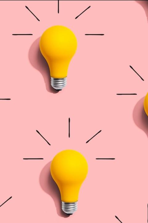 graphic of light bulbs on a pink background representing ideas and predictions for brand purpose in 2025