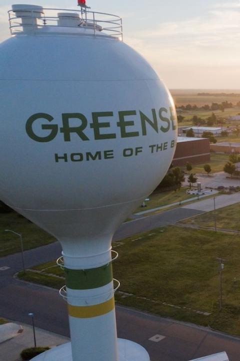 An aerial view of Greensburg, Kansas, at sunset, featuring the town's water tower.