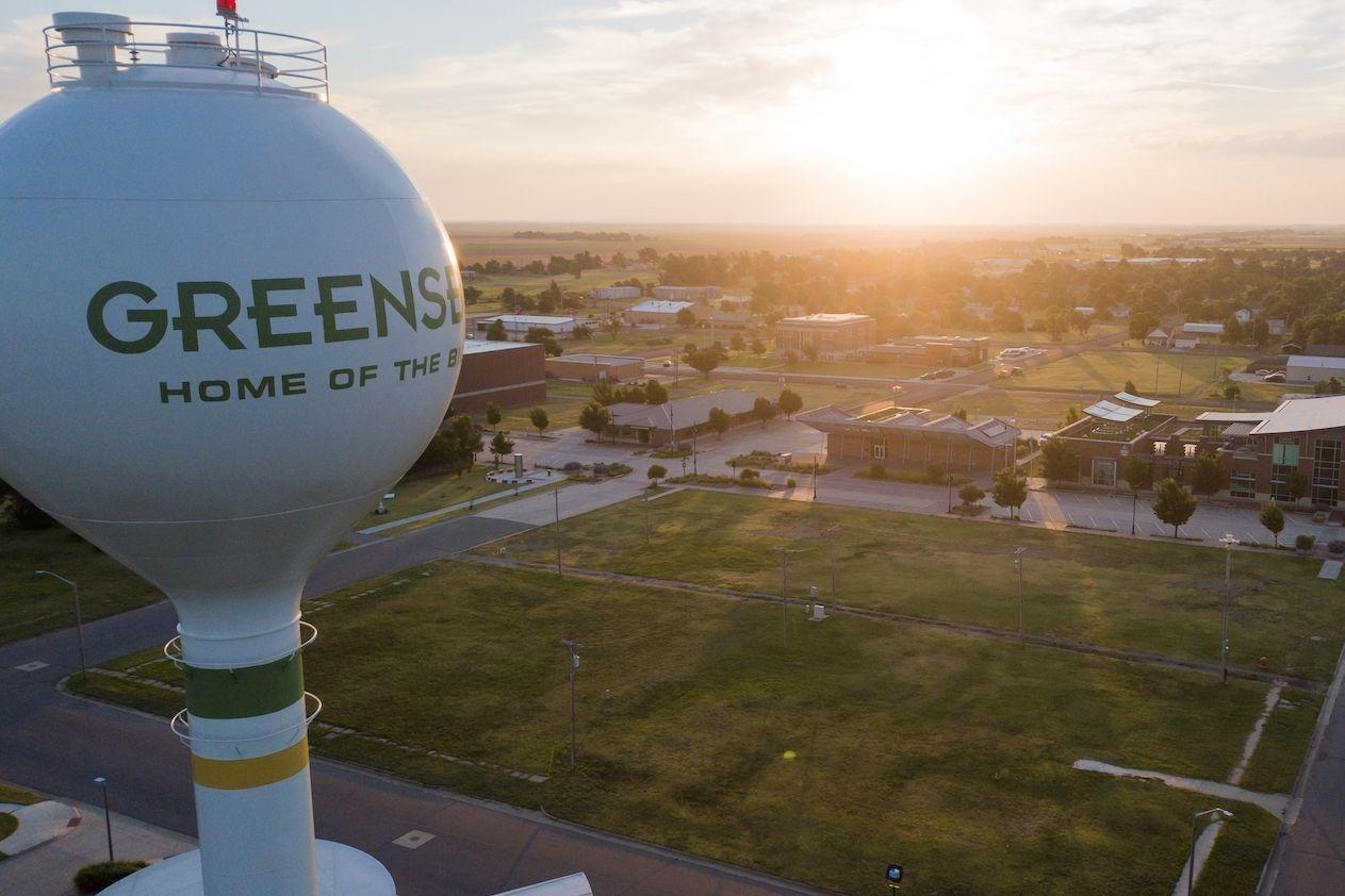 An aerial view of Greensburg, Kansas, at sunset, featuring the town's water tower.