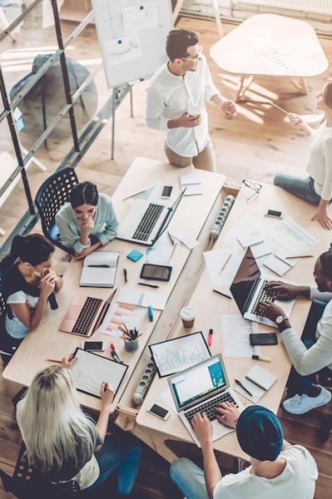 aerial view of young people working in a modern office - how professionals can prepare for harmonized sustainability reporting requirements