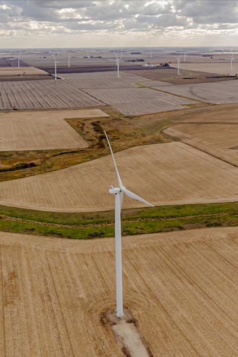 An aerial view of wind turbines scattered across farm fields in Howard County, Iowa.