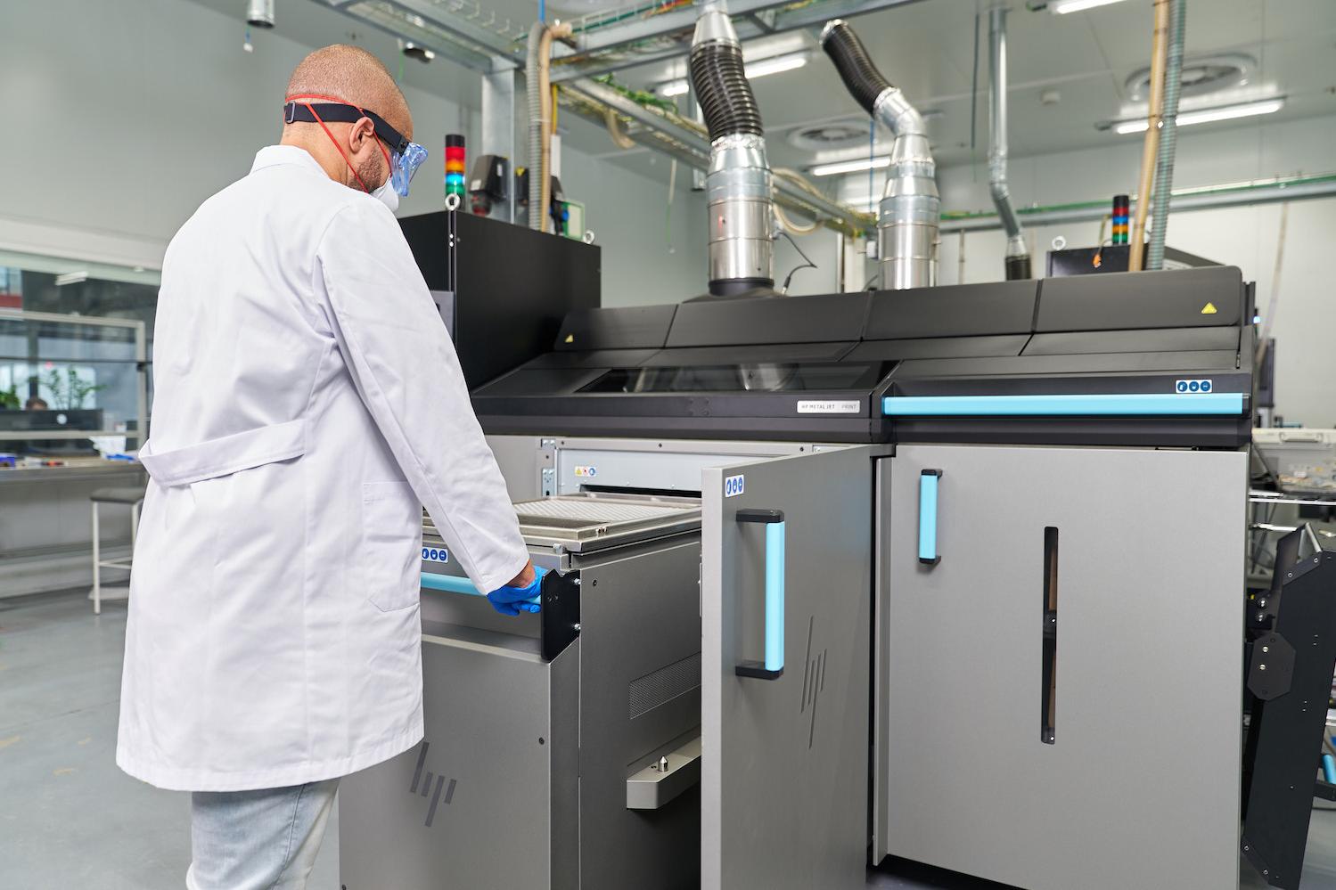 HP Metal Jet S100 Operator 3D printing metal parts in a lab