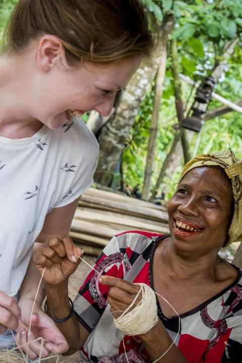 A traveler and a local laugh together on an Intrepid Travel trip. 