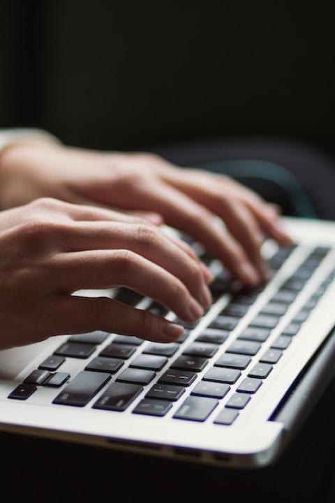 A person typing on a laptop.
