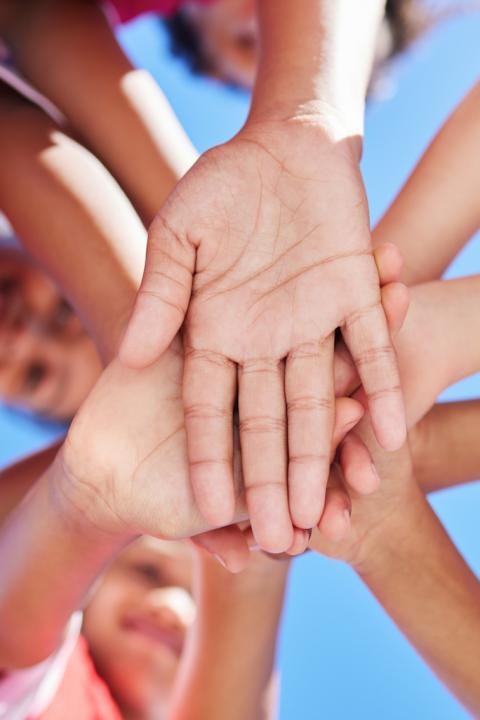 kids putting hands in center - youth sports