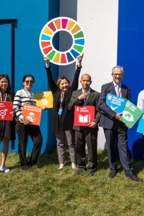 Leaders pose with blocks representing the SDGs at the SDG Pavilion Climate Week 2023