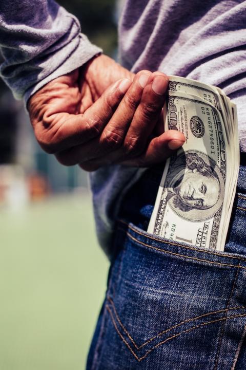 man puts money in his pocket — climate finance — we have change in our pockets — vote with your dollar