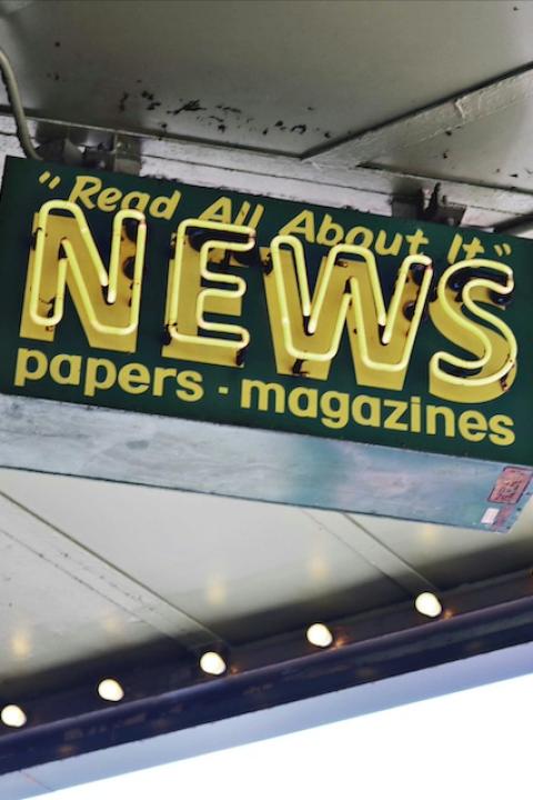 A sign reads "Read all about it. News. Papers. Magazines." 