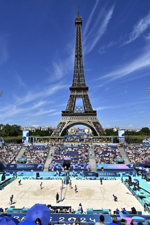 Paris Olympics 2024 — a crowd watches a womens volleyball match behind the eiffel tower