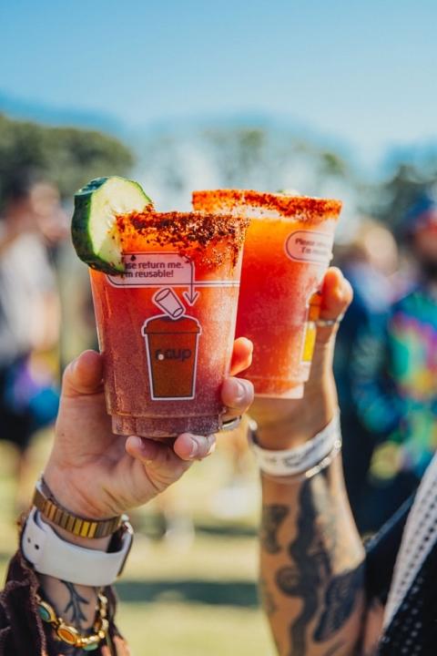 people toasting with reusable cups at a music festival — sustainability at music festivals