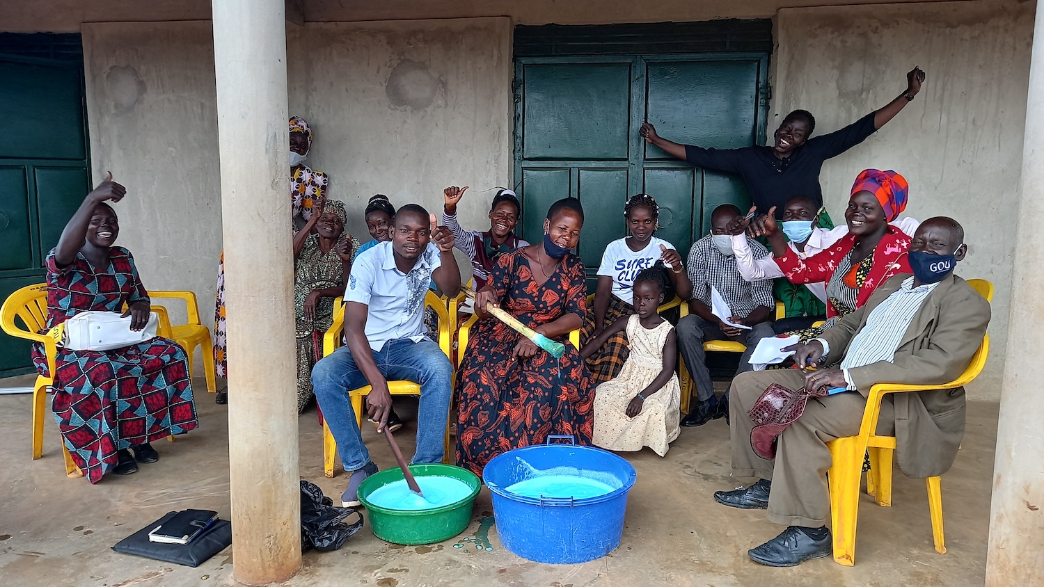 A group of community members sit together during a Surge for Water soapmaking lesson.