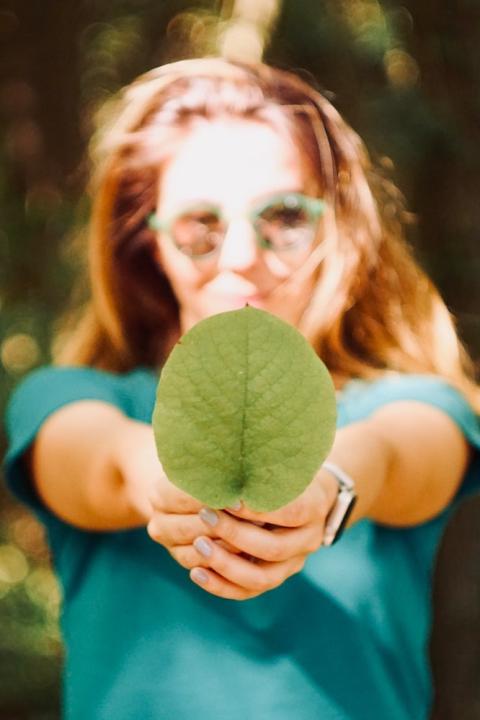 woman holding leaf - ESG and sustainability trends