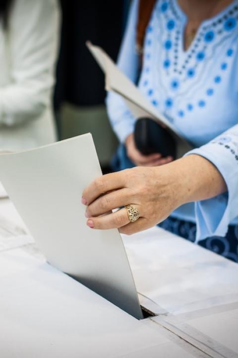 woman puts ballot in a ballot box — voting — paid time off for voting