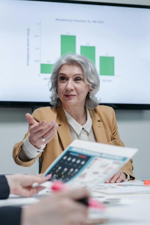 A woman sitting in a meeting — workplace ageism 