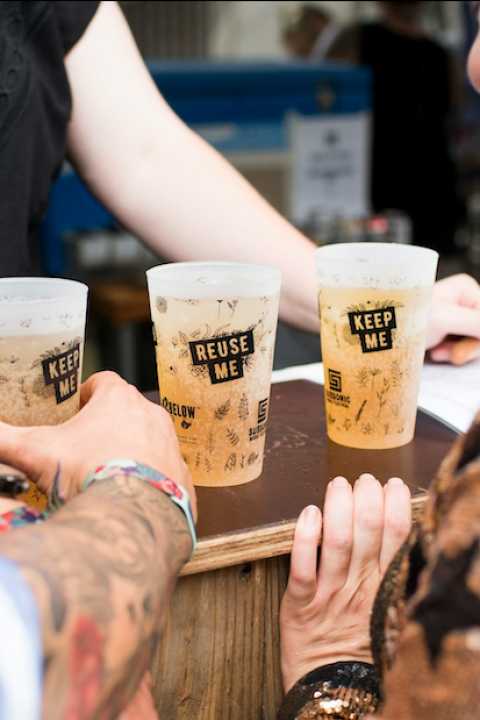 people get drinks in reusable cups at a music festival in australia - reuse and refill systems
