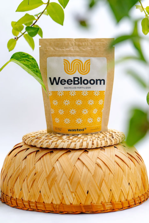A package of WeeBloom fertilizer surrounded by plant cuttings.